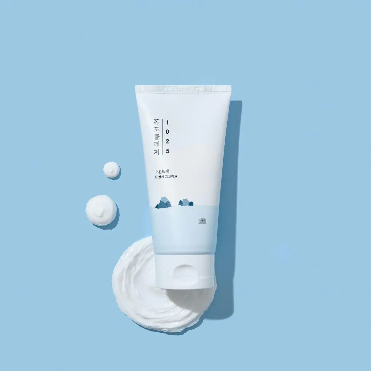 Round Lab 1025 Dokdo Cleanser 150ml on blue background, featuring gentle formula for hydration and skin barrier support.