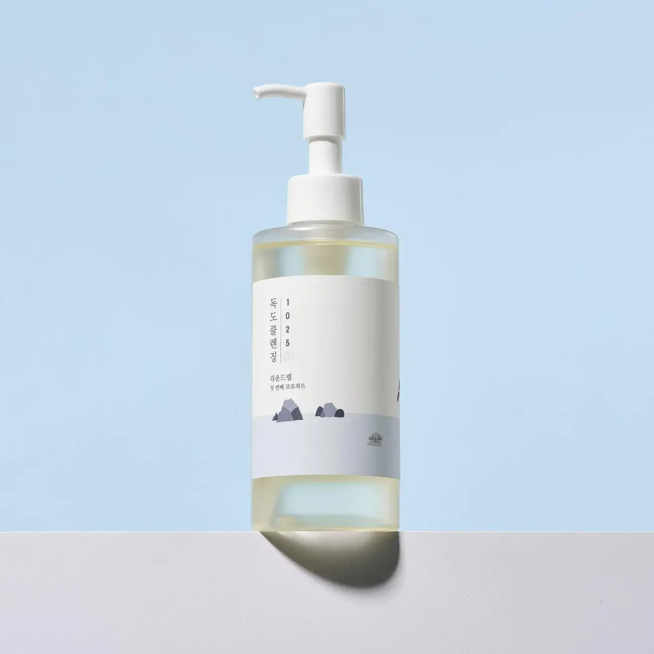 Round Lab 1025 Dokdo Cleansing Oil 200ml bottle on a pastel background, ideal for makeup removal and skin hydration.