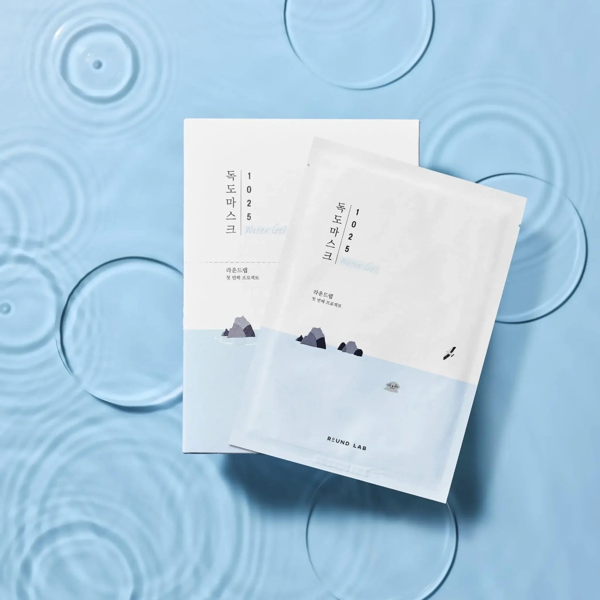 RoundLab Dokdo Hydrating Water Gel Mask packaging surrounded by water droplets showcasing its refreshing qualities.