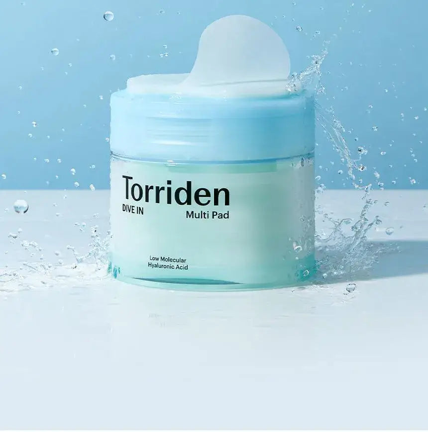 Torriden Dive In Multi Pad container amidst water droplets, showcasing 80 hydrating pads enriched with Hyaluronic Acid.