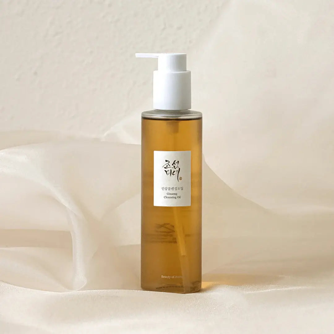 Beauty of Joseon Ginseng Cleansing Oil 210ml in a sleek bottle against soft fabric backdrop.