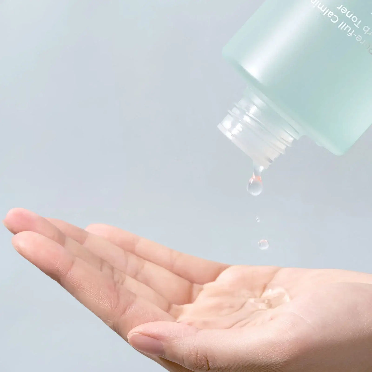 Drop of Numbuzin No.1 Pure-Full Calming Herb Toner falling into a hand, showcasing its lightweight texture.