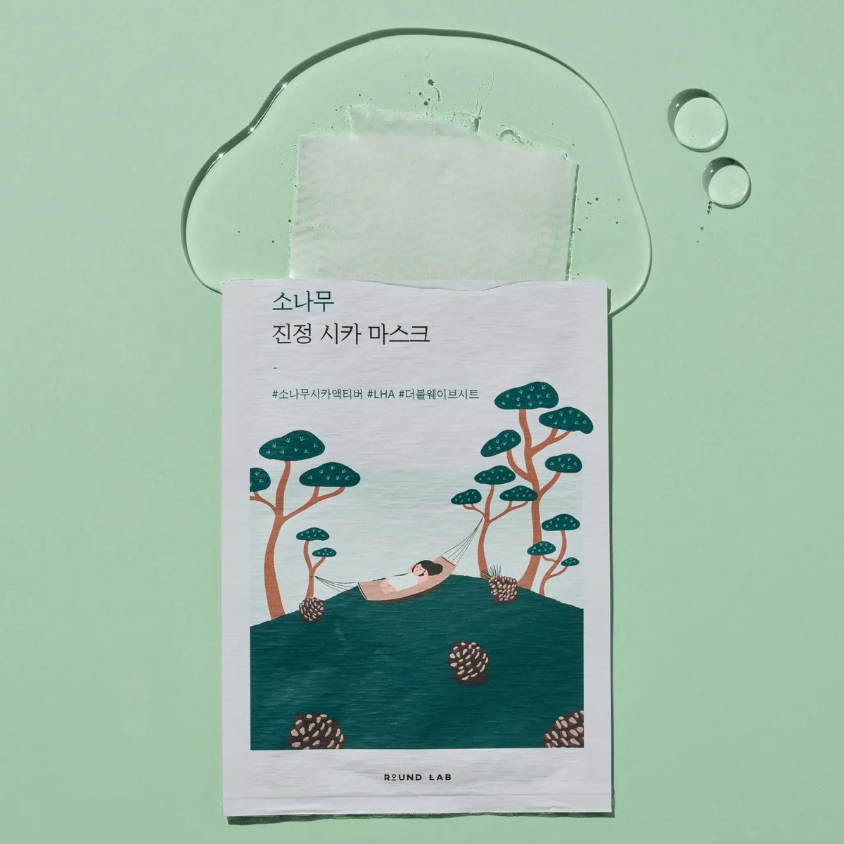 RoundLab Pine Calming Cica Mask with calming essence on a green background for soothing skin and moisture.