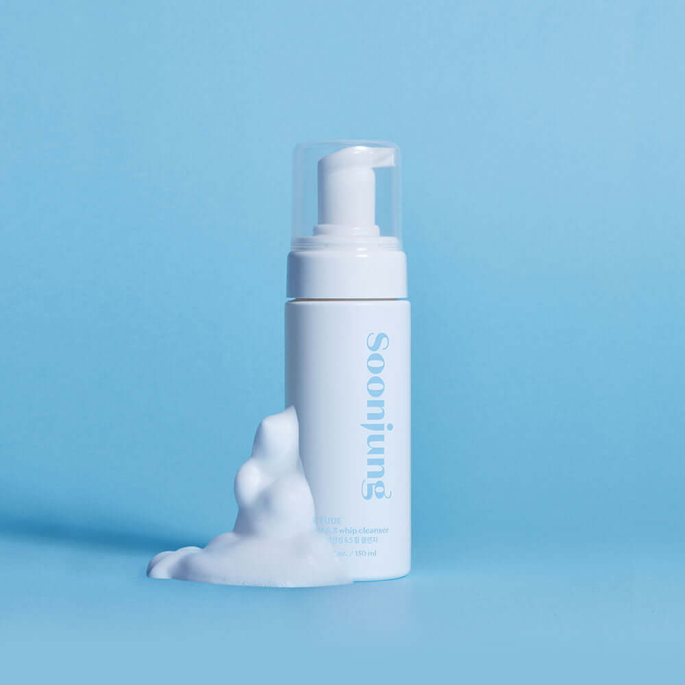 SoonJung pH 6.5 Whip Cleanser bottle with foamy cleanser on a blue background, ideal for sensitive skin care.